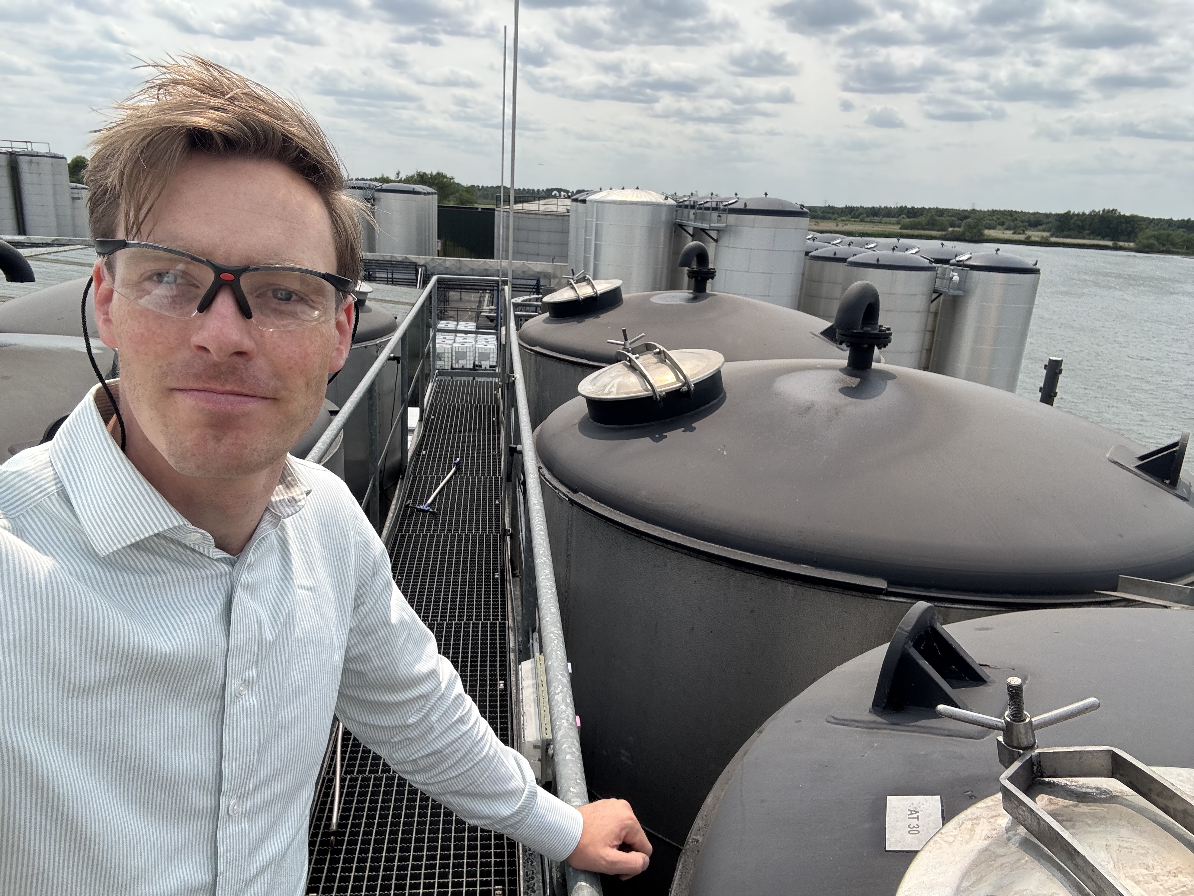Jaap op locatie tussen industriële opslagtanks